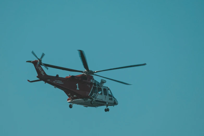 a helicopter flying in the blue sky above