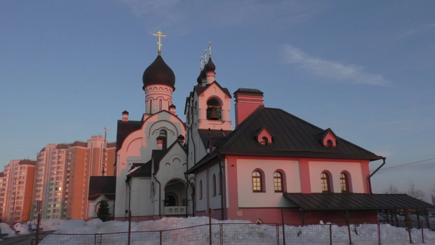 a white and red church with three domes