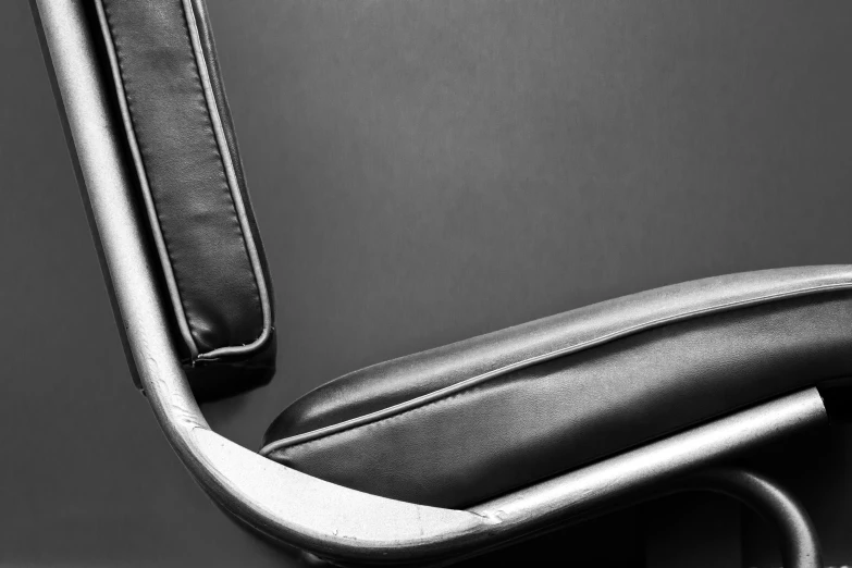 a black leather office chair sitting against a wall