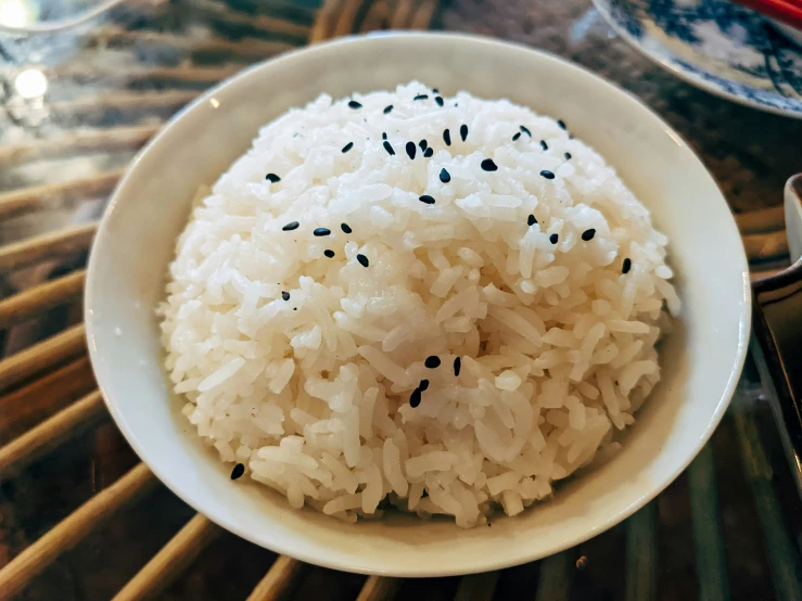 a white bowl with black sesame seeds inside