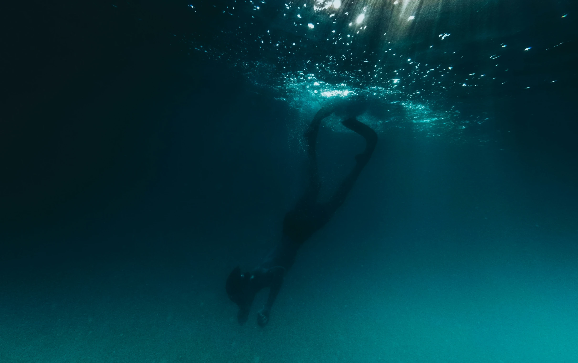 the image is taken from under the water looking like it's divering into the ocean