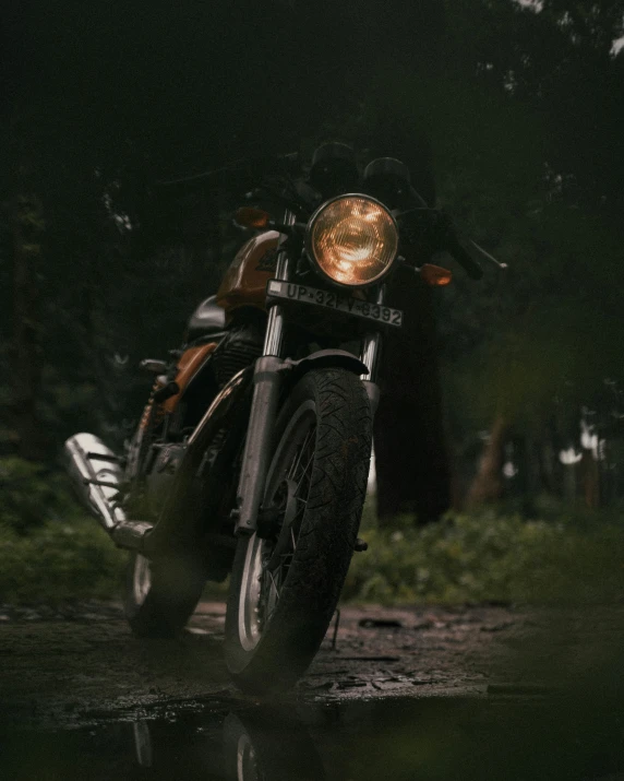 an old fashioned black motorcycle parked on wet road