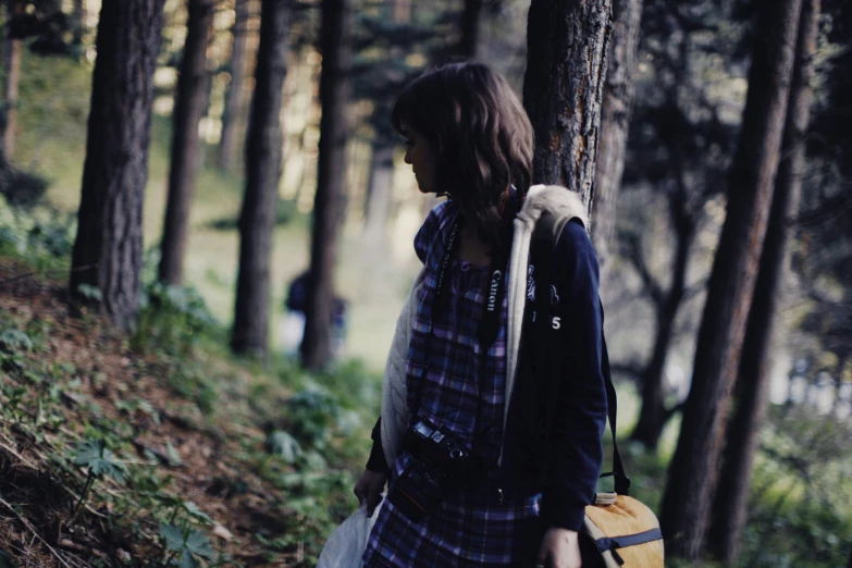 the woman is carrying a purse through the forest