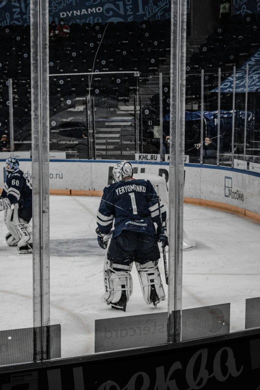 a hockey game in progress with the hockey players looking at the goal