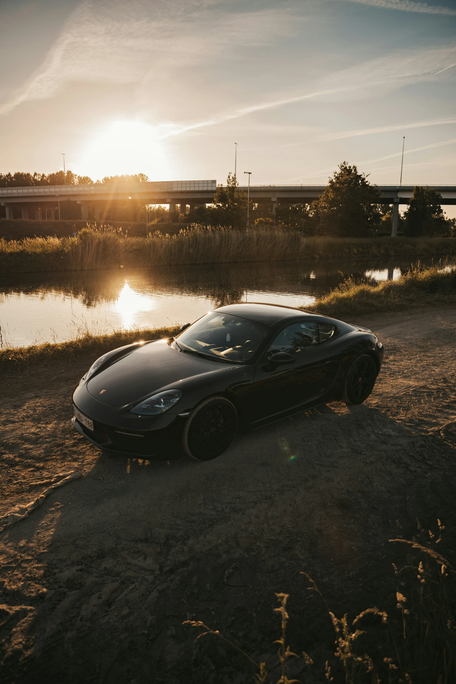 a dark colored sports car in the middle of the desert