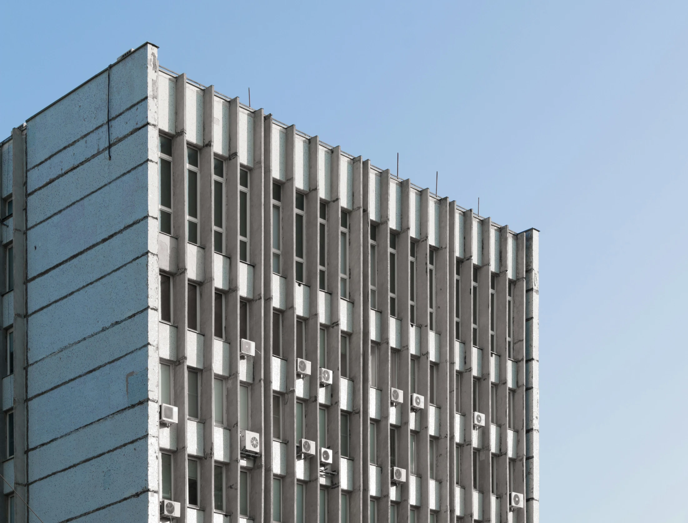 a gray building with windows and street signs in a foreign language