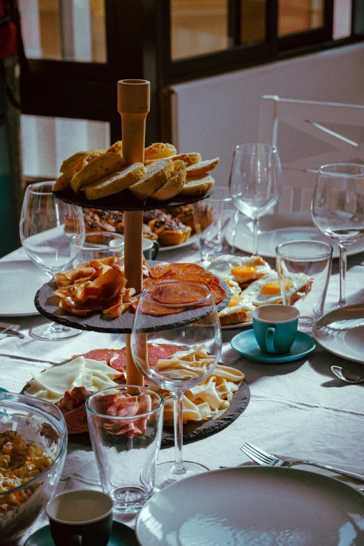 a table set up with different foods, glasses and dishes