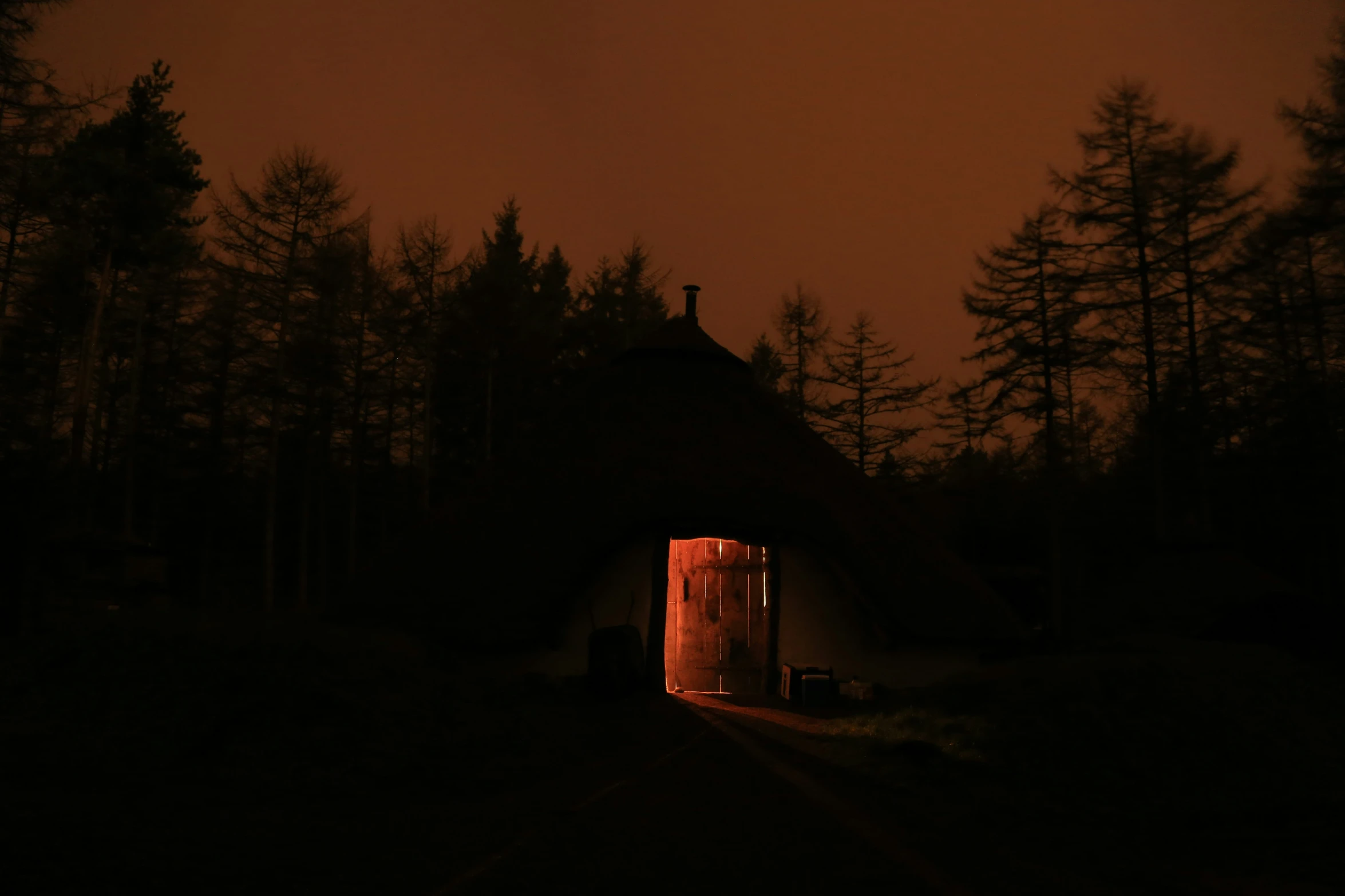 dark picture of a lit entrance to a dimly lit building