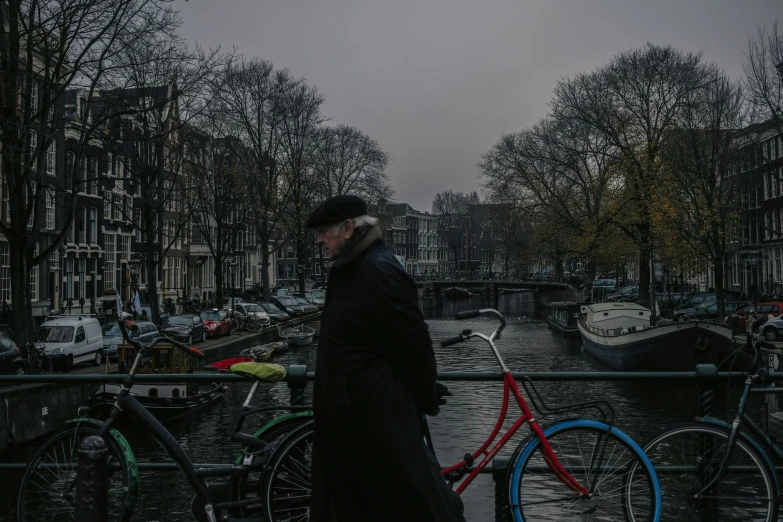 two people are walking their bikes near a river