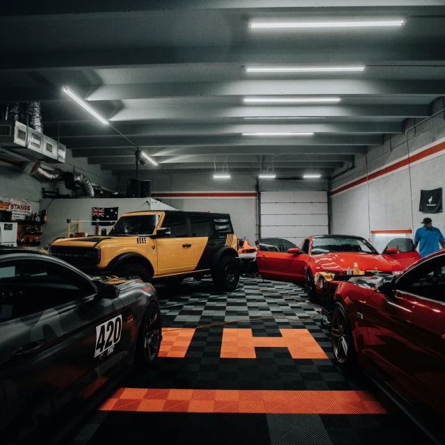 various cars are parked in an automobile garage