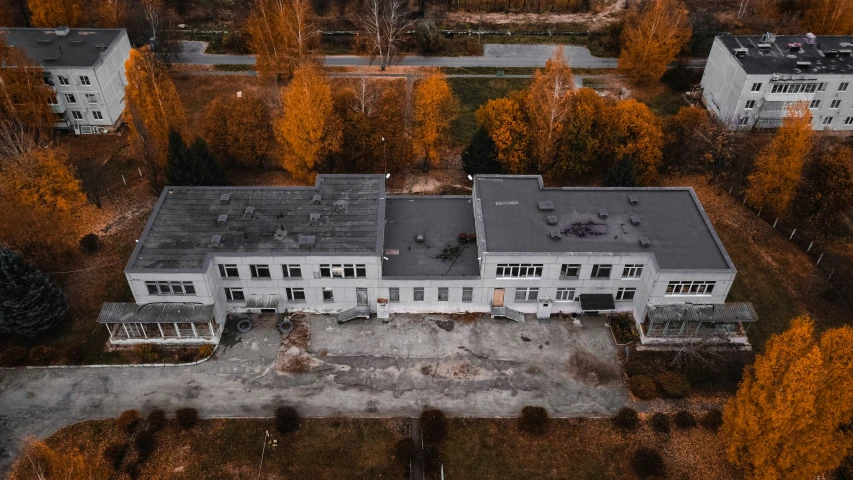 an aerial view of a large white home surrounded by trees