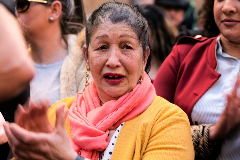 a woman is surrounded by other people as they sit down and talk