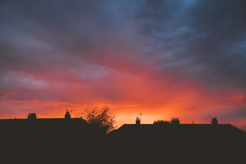 a red sky that is over some houses