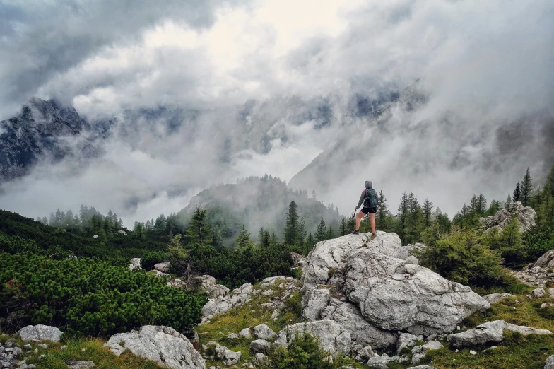 a lone hiker standing on top of a rocky mountain ridge