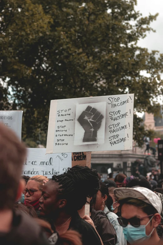 people with signs hold up their fists for the president