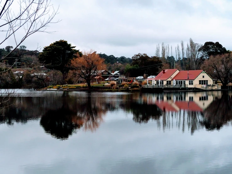 a building next to water in front of trees