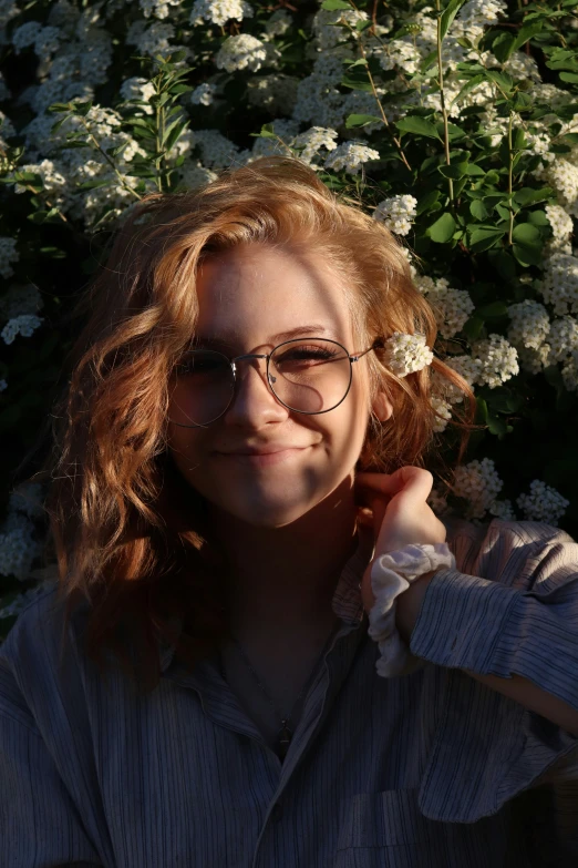 a woman standing next to a bunch of white flowers