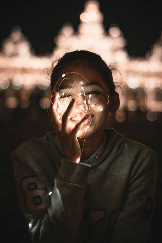 a  with her hands in her face with glowing lights in the background