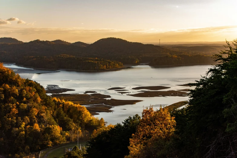 the sun sets over a lake and mountain landscape