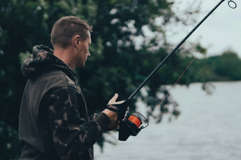 a man holding a fishing pole and spinning it