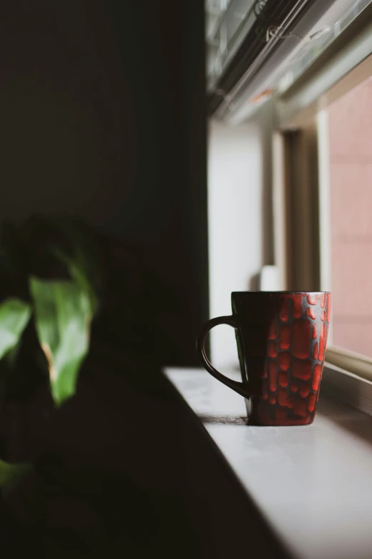 the view from an open window of a cup sitting on a window sill