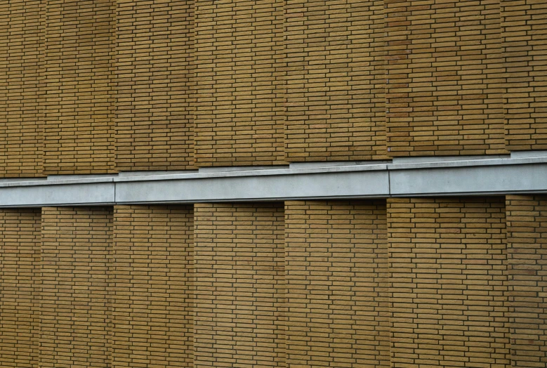 a brick building has a row of vertical gutters on it