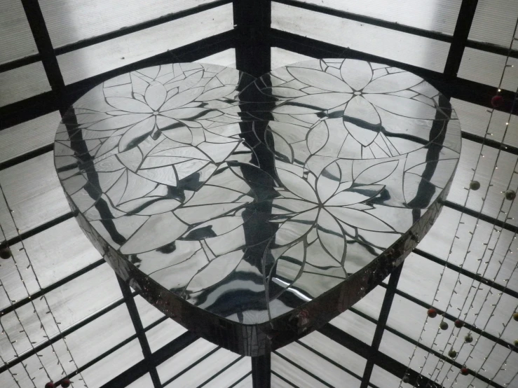 a round glass table with many flowers on it