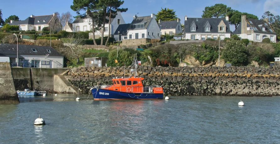 a tug boat in the water near houses