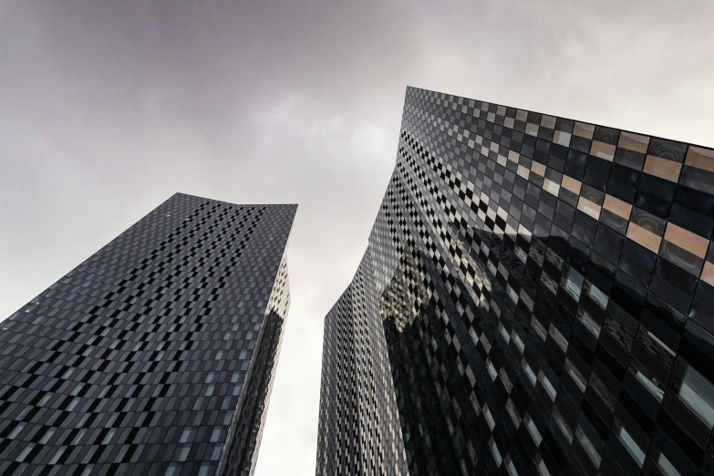 looking up at two tall skyscrs in the city