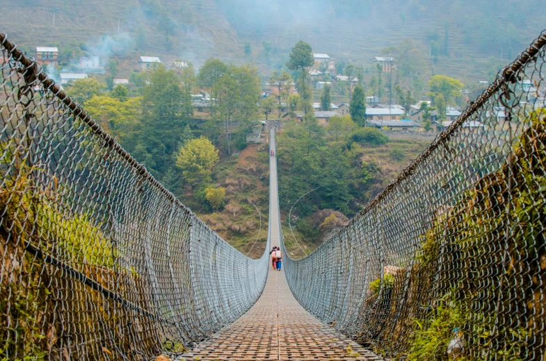 a person walking across a bridge with a lot of netting