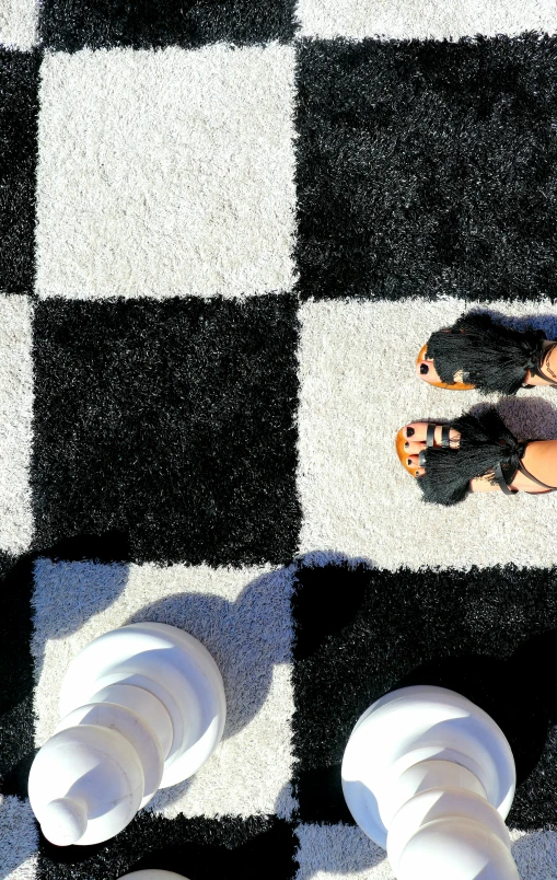 a man walking on a checkered sidewalk with shoes