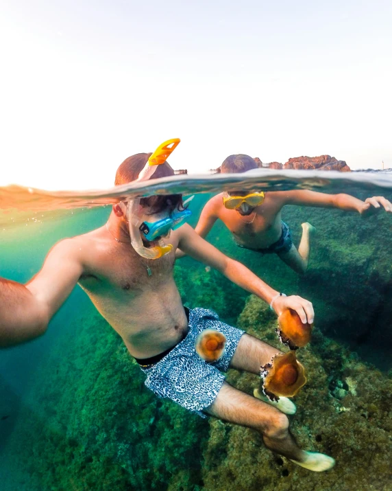 a couple of people swimming and holding onto a bottle