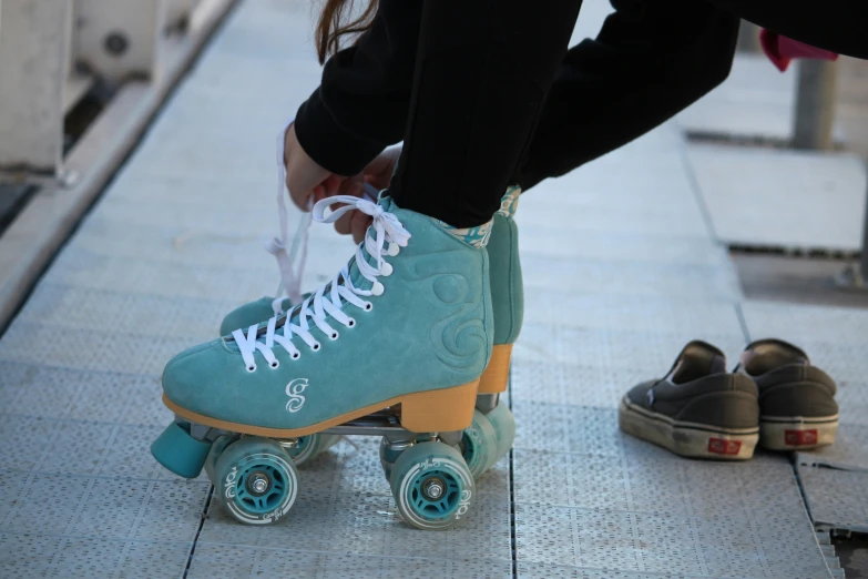 the woman is tying her roller skates to the ground