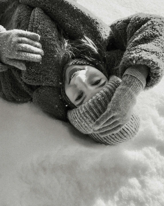 a woman wearing a beanie lying on her side