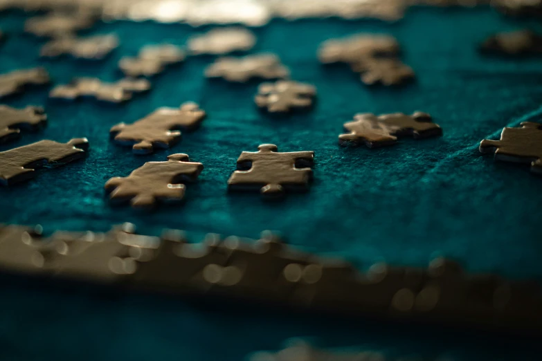 closeup of metal puzzle pieces on green fabric