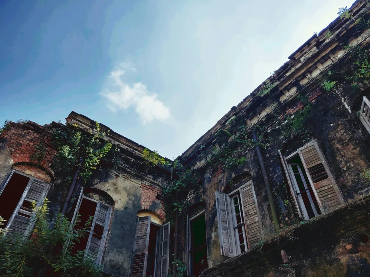 an old building with lots of windows and vines on it