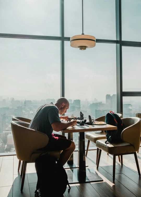 a person sitting at a table with a laptop