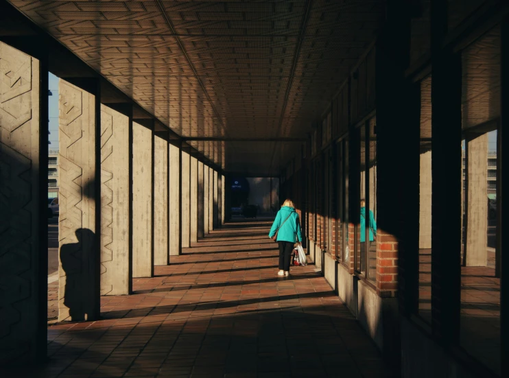 the woman in blue is walking down the sidewalk