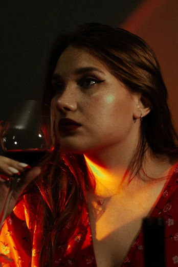 a woman with long hair is holding a glass of wine
