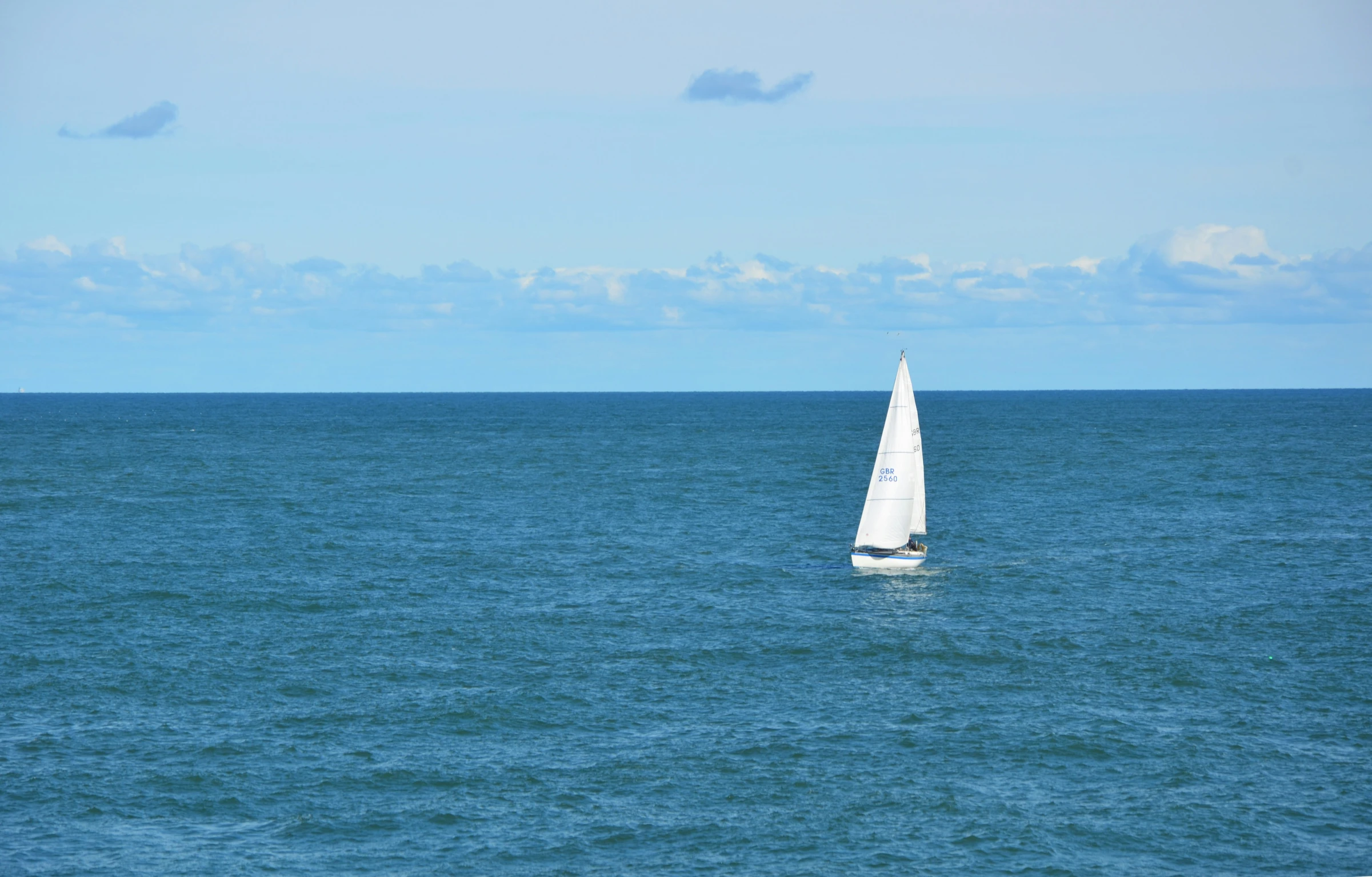 a sailboat sailing on the ocean, just out on its journey