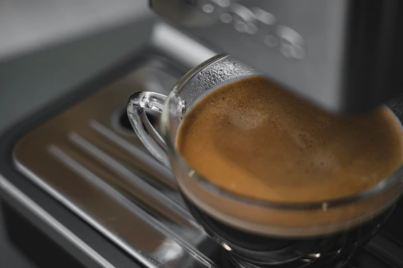 a espresso machine is filling with a brown liquid