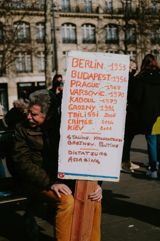 a man holding up a sign that says be run