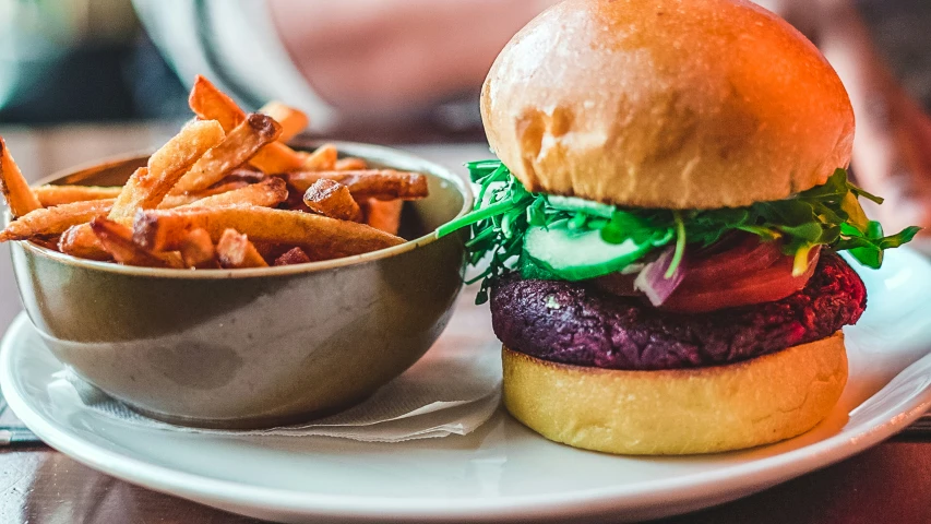 a hamburger with lettuce, tomato and sauce served with fries