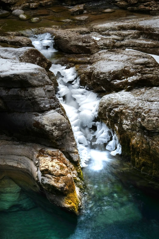 a water fall has frozen around the rocks