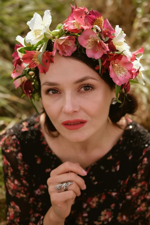 a woman wearing a flower crown standing in the forest