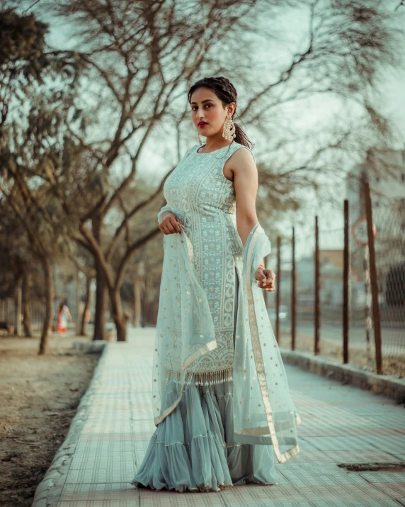 a woman poses on a city street in a dress