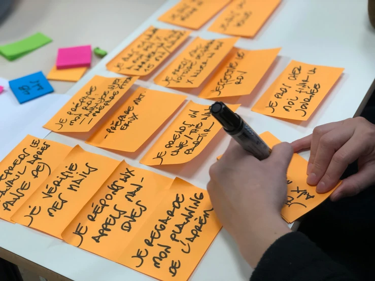 a handwritten note sits on a table near a pile of notes