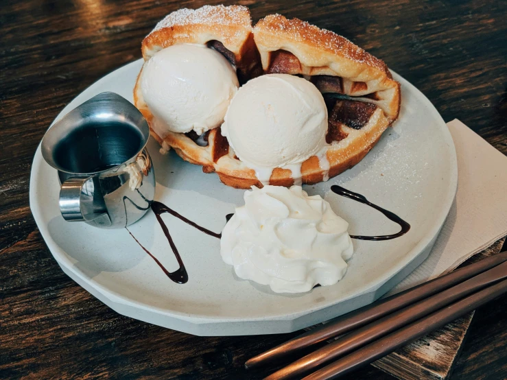 a dish with waffles and ice cream sits on a plate
