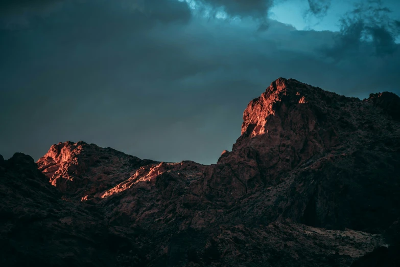 a mountain range under a blue cloudy sky