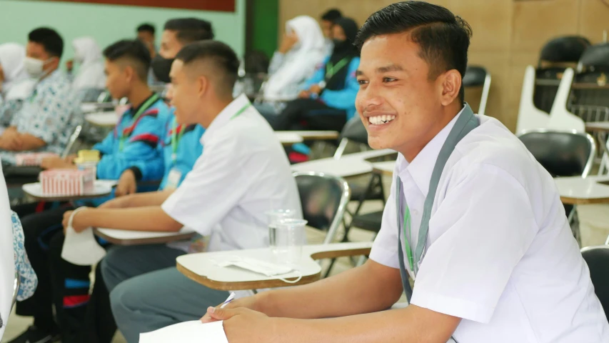 several people in a classroom all smiling for the camera